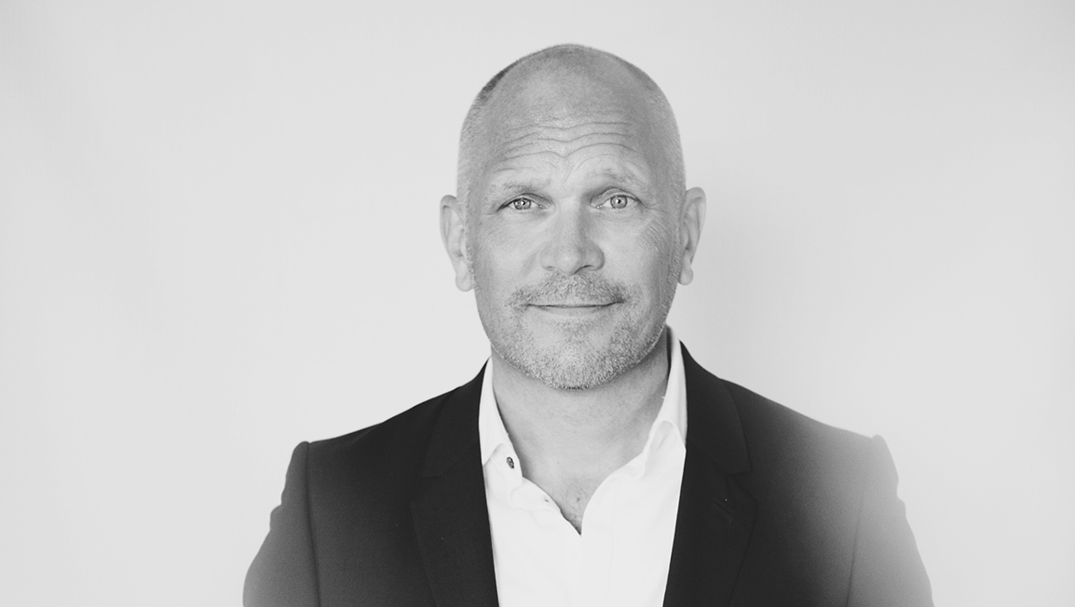 Person iförd svart kavaj och ljus skjorta.
